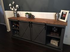 an entertainment center with sliding doors on the front and side panels that open up to reveal wine bottles