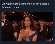 a woman in a blue dress clapping at an event