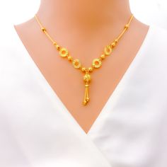 This 22k gold necklace, weighing 9.1 grams, features a trendy design with a dangling orb, polished in a radiant yellow gold finish. The necklace is 17 inches long, with a drop length of 1.25 inches, and includes 1 inch of adjustable links for a perfect fit, secured by an S lock. The singular orb adds a modern touch, making this piece a standout accessory. Ideal for those seeking a blend of contemporary style with the timeless elegance of gold, this necklace is perfect for adding a touch of sophistication to any look, whether for daily wear or special occasions. PRODUCT DETAILS Gold Purity(karat): 22k Gold Weight(grams): 9.1 Item Finish: Yellow Gold Necklace Length: 17" Drop Length: 1.25" Adjustable Links: 1" Links Lock Style: S Lock 22k Gold Necklace, Lock Style, Yellow Gold Necklace, 22k Gold, Necklace Length, Gold Finish, Contemporary Style, Timeless Elegance, Daily Wear