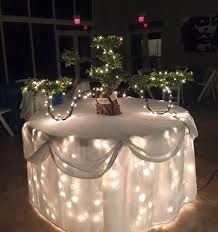 a table with lights on it and some trees in the centerpieces that are lit up