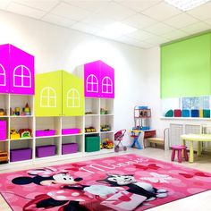 a child's playroom with colorful walls and furniture, including a mickey mouse rug