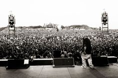 a man standing on top of a stage in front of a large group of people