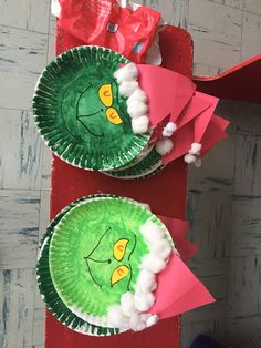 two paper plates with green and red designs on them sitting on a table next to each other