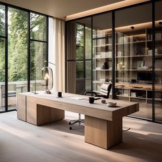 an office with large windows and a desk in front of glass doors that look out onto the outdoors