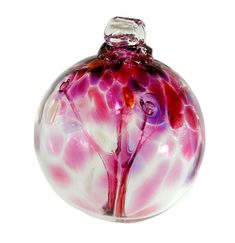 a pink and white glass ornament sitting on top of a table