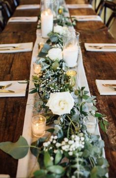 a long table with candles, flowers and greenery is set for an elegant dinner