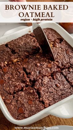 chocolate brownie baked oatmeal in a white dish with a serving spoon