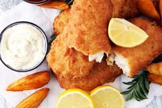 fried fish with lemon wedges and dipping sauce