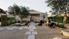 two people sitting on benches in the middle of a yard with rocks and gravel around them