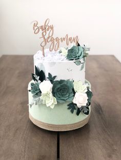 a white and green cake with flowers on top