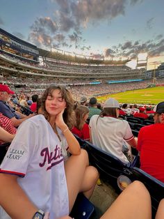 a woman sitting in the stands at a baseball game