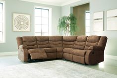 a living room with a large sectional couch in the middle and a rug on the floor