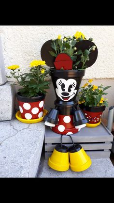 mickey mouse planters are sitting on the steps