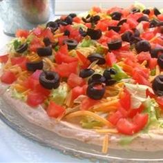 a pizza with many toppings sitting on a table next to a glass container filled with water