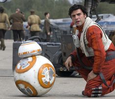 a man kneeling down next to a star wars bbg ball