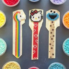 several plastic spoons with different colored beads in them and one has a hello kitty design on it