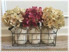 three vases with flowers in them sitting on a table