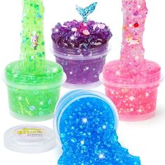 four plastic containers filled with different colored glitters