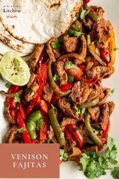 a plate filled with meat, peppers and tortilla on top of a table