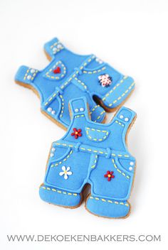 two cookies shaped like overalls with flowers on them