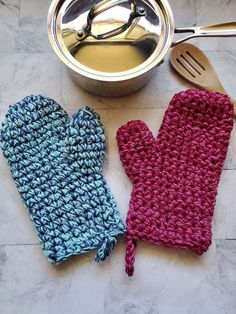 two oven mitts are next to a pot and spoon