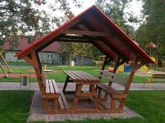 a wooden picnic table and benches in a park