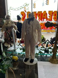 a statue of a man wearing a white suit and bow tie in front of a window