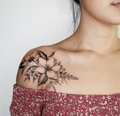 a woman with a flower tattoo on her upper arm and shoulder is looking at the camera