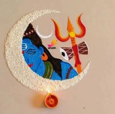 a decorated cake with an image of lord ganeshi on the moon and a lit candle