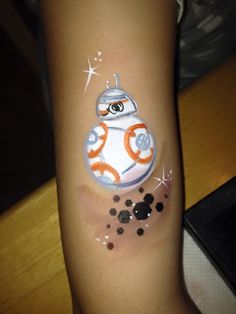 a star wars tattoo on the arm of a person's leg, with an orange and white bbg character painted on it