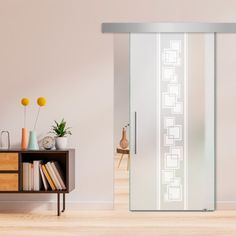 a room with a book shelf and a sliding glass door that has an abstract design on it