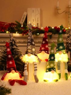 lighted christmas trees and stockings in front of a fireplace