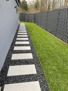 a stone path in the grass between two buildings