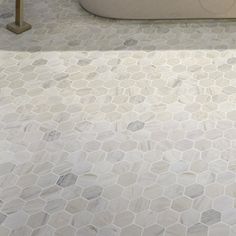 a bath tub sitting on top of a white tiled floor