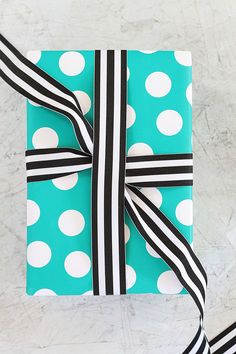 a blue and white gift wrapped in black and white polka dots