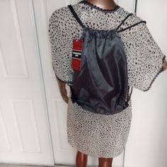 a mannequin wearing a leopard print dress with a black backpack on it's back