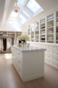 a white closet with an island in the middle