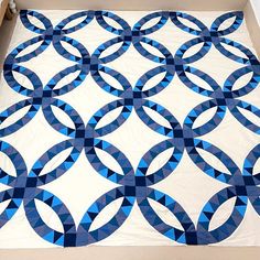 a blue and white quilt in a box with the lid open to show it's design