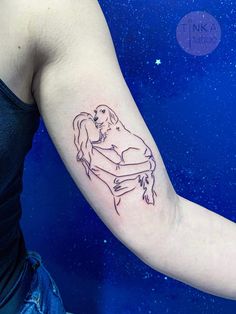 a woman with a tattoo on her arm holding a dog and hugging it's head