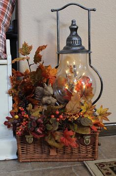 a basket filled with autumn leaves next to a lamp