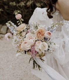 a woman holding a bouquet of flowers in her hand