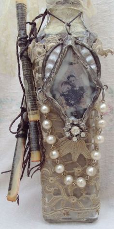 an old fashioned bottle is adorned with pearls and beads