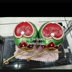 two red and green decorated eggs sitting on top of a table