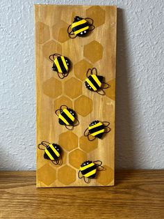 a wooden board with four bees on it