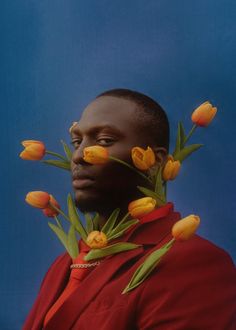 a man in a red suit with yellow tulips on his head and chest