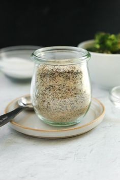 a glass jar filled with seasoning sitting on top of a plate