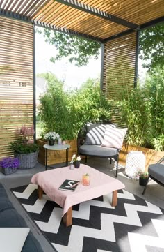 an outdoor living area with couches, tables and potted plants