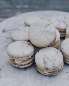 there are many macaroons sitting on the marble table top, all covered in white icing