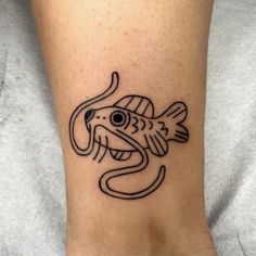 a small black and white fish tattoo on the ankle, with an octopus in it's mouth