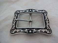 A new buckle from Horse Shoe Brand Hardware, designed by Jeremiah Watt. A stainless steel square buckle in the black Floral pattern.The measurements reflect the size of material that the buckle and tip will fit on to (the length measured from inner edge to inner edge).  For example, the 1 1/2" set will fit an 1 1/2" wide piece of material. Classic Black Belt Buckles With Silver Buckle, Classic Black Concho Belt Buckles, Western Black Belt Buckles With Silver Detail, Western Black Belt Buckles With Silver Buckle, Black Western Belt Buckles With Silver Buckle, Classic Black Rectangular Belt Buckles, Vintage Black Adjustable Belt Buckles, Vintage Adjustable Black Belt Buckles, Black Floral Pattern